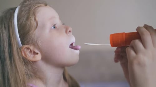Girl Having Throat Examined with Tongue Depressor