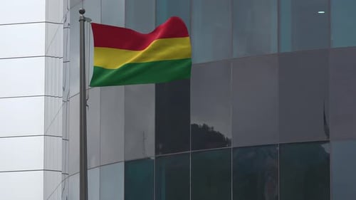 Bolivian Flag Waving on Pole in Front of Corporate Building