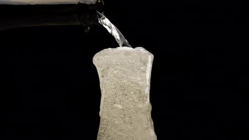 Glass of Sparkling Drink Overflowing With Foam
