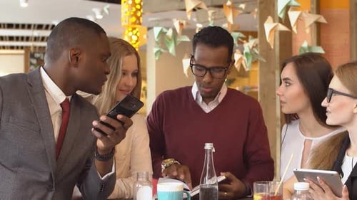 Young Adults Looking at Smartphone in Cafe