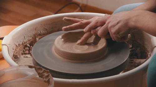 Hands Forming Clay Bowl on Pottery Wheel Close Up