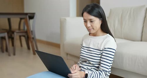 Woman Types on Laptop Computer in Living Room