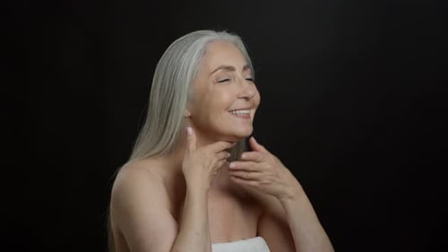 Elegant Senior Woman Massaging Face and Neck