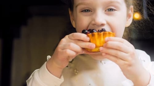 Young Girl Enjoys a Berry Tart Snack