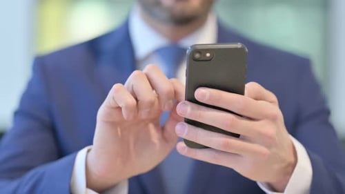 Hands of Middle Aged Businessman Using Smartphone Close Up