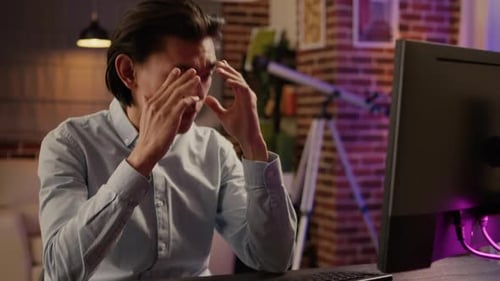Stressed Young Adult Working at Computer at Night