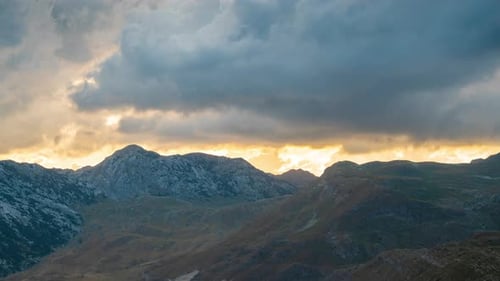 Mountains and Golden Light Under Moody Clouds