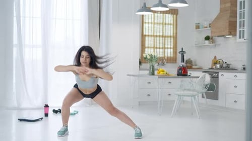 Woman Stretching and Doing Leg Lifts at Home
