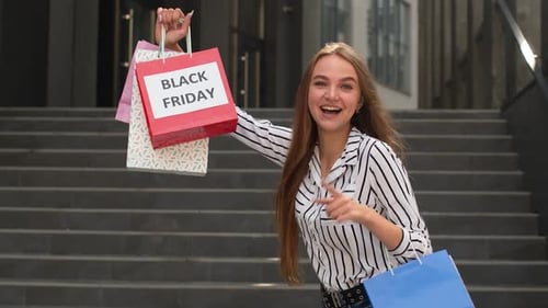 Woman Smiling with Black Friday Shopping Bags