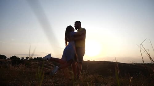 Romantic Couple Embracing at Sunset in Rural Field