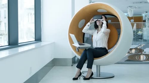Woman Using VR Headset in Modern Office Chair
