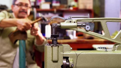 Man Making Shoes with Sewing Machine and Hammer