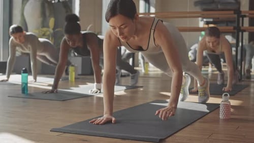 Women Standing in Plank during Group Training