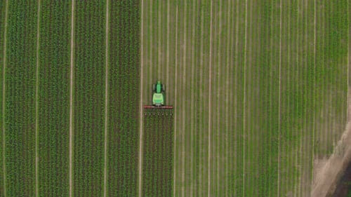 Luftbild: Traktor arbeitet auf kultivierten Feldern Ackerland, Beruf der industriellen Landwirtschaft