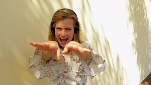 Blonde Woman Listening to Music and Dancing