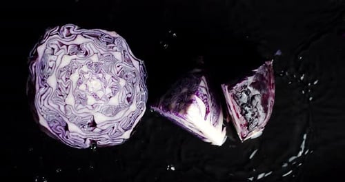 Halved Red Cabbage on Dark Reflective Surface