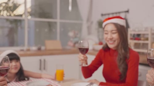 Friends Celebrating Christmas with Wine in Cozy Kitchen