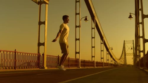 Young Adult Skipping Rope on Bridge at Sunset