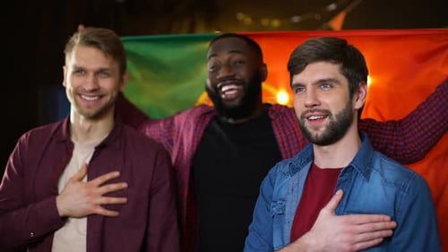 Three Young Adults with Flag and Hands Over Hearts