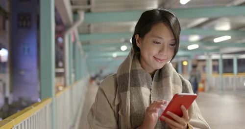 Woman use of mobile phone in city at night