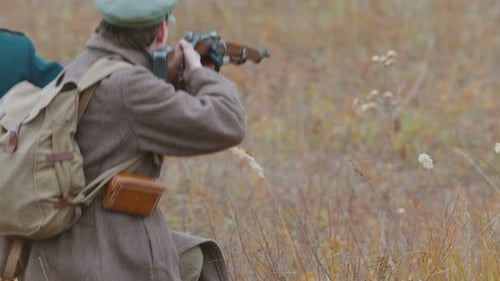 Ein Mann, Soldat, der auf dem Schlachtfeld steht und mit einer Pistole zielt