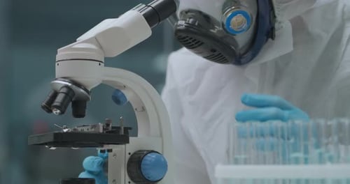 Scientist in Hazmat Suit Uses Microscope in Lab