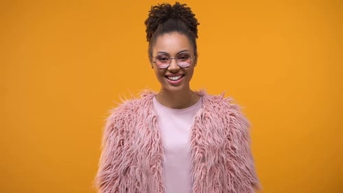 Woman in Pink Smiling Against Orange Background