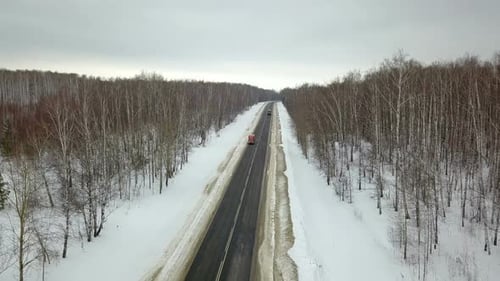 Truck Travels Through Snowy Winter Forest Road