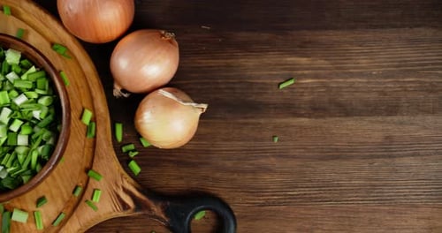 Onions and Chopped Green Onions on a Cutting Board
