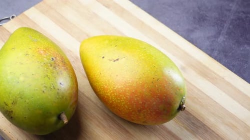 Fresh Green Mango on a Chopping Board on Table