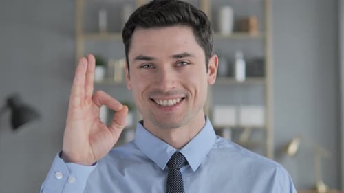 Young Adult Giving OK Hand Gesture and Smiling