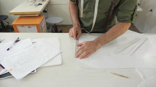 Man Designing Clothing Patterns in Design Studio
