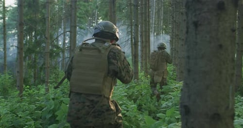 Operação militar com grupo de soldados atacando a linha inimiga em floresta densa durante o dia