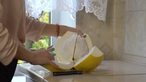 Woman Preparing Pomelo in Kitchen