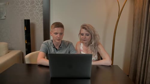 Couple Using Laptop Together at Table Indoors