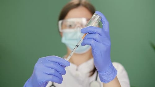 Medical Worker Draws Vaccine into Syringe Close Up