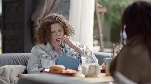 Boy Using Tablet at Lunch in Cafe