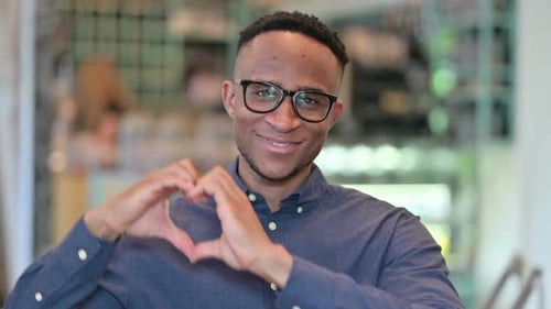 Young Man Smiling and Making Heart Shape With Hands
