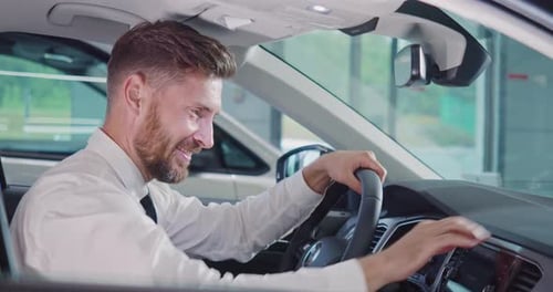Smiling Man Enjoying New Car in Showroom