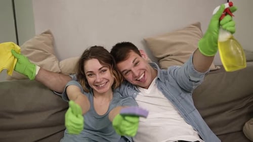 Portrait of a Young Cheerful Couple in Green Rubber Gloves