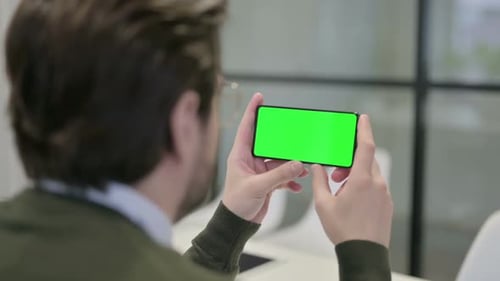 Man Holding Smartphone with Green Screen Horizontally