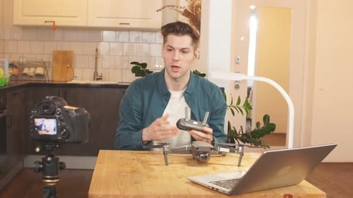Der
schöne männliche Blogger nimmt ein Video auf, das zu Hause vor der Kamera sitzt. Remote-Arbeit während