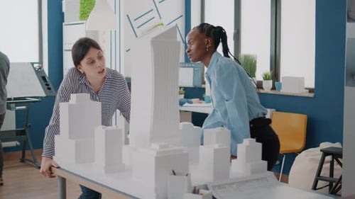 Team of Multi Ethnic Women Analyzing Maquette on Table to Design Building Model