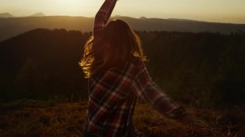 Happy Woman Spinning in Mountain Landscape at Sunset