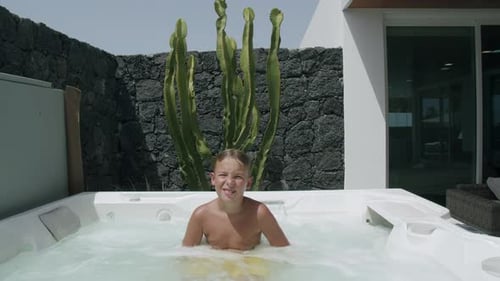 Kid relaxing in outside spa bath