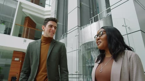 Multiethnic Man and Woman Walking in Business Center and Talking
