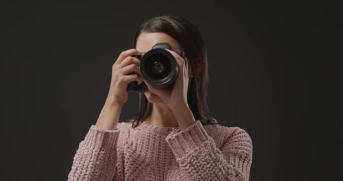 Woman Taking Picture with Camera in Studio