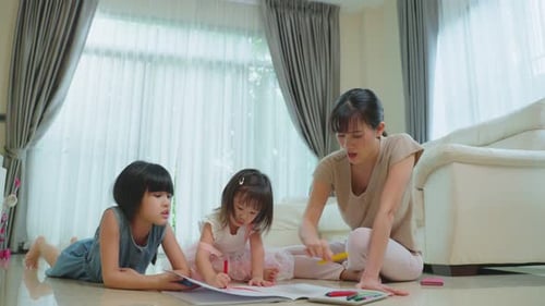 Mother and Two Girls Coloring Together Indoors
