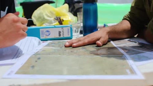 Close-up das mãos dos comandantes planejando sua próxima missão