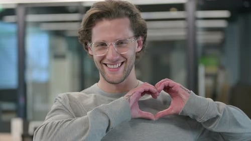 Man Smiling and Making Heart Shape with Hands